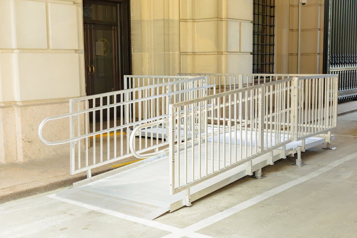 Modular aluminum ramp with continuous handrails at a residential home