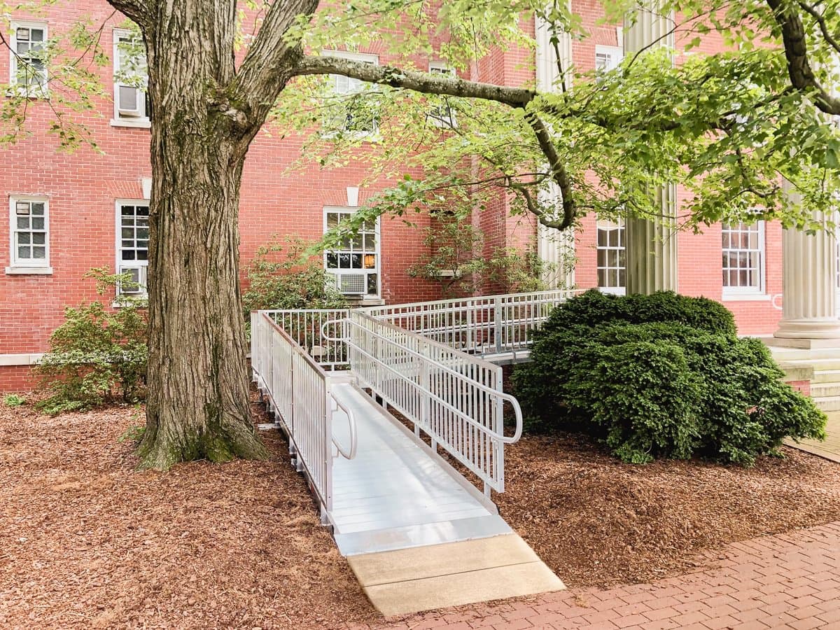 Commercial aluminum access ramp with handrails at a business entry