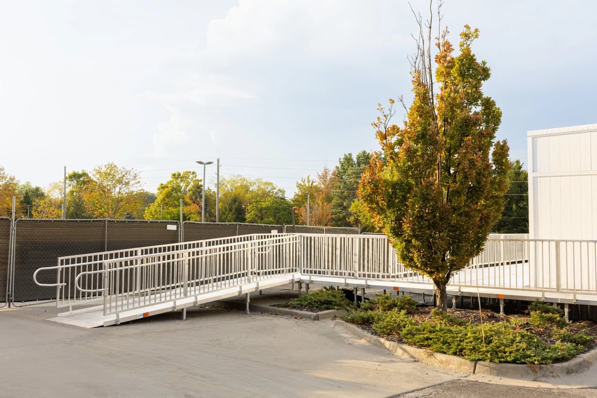 Aluminum wheelchair ramp with adjustable legs and composite footpads at a home
